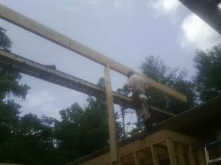 Carpenter setting a ridge beam over a new addition frame — Ice Dam Removal by Roofing Brothers in Johnson Creek
