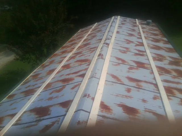 Rusted metal roof panels with new wood purlins before replacement — Storm Damage Roof Repair in Johnson Creek by Roofing Brothers