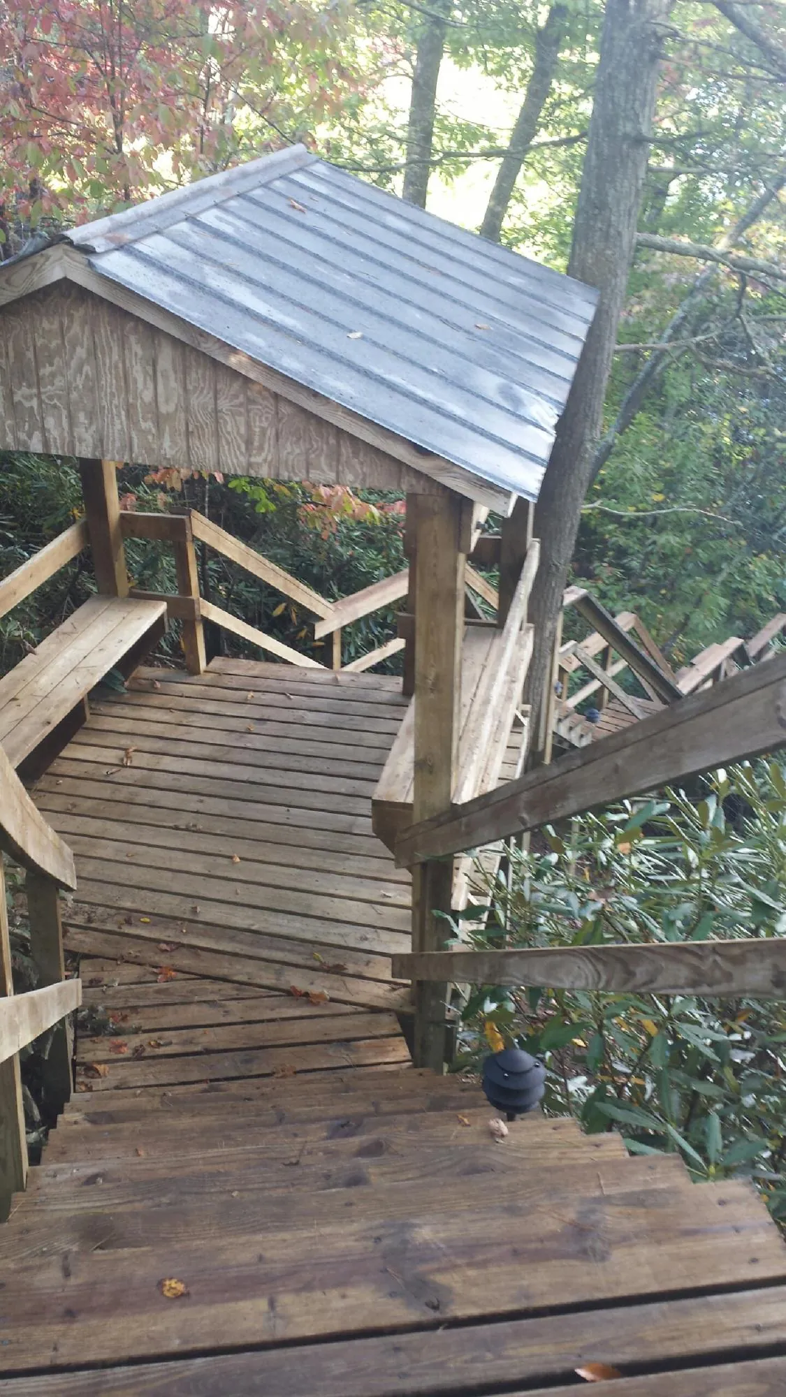 Metal roofed shelter over wooden steps on a wooded walkway — Skylight Repair & Installation work by our crew in Johnson Creek
