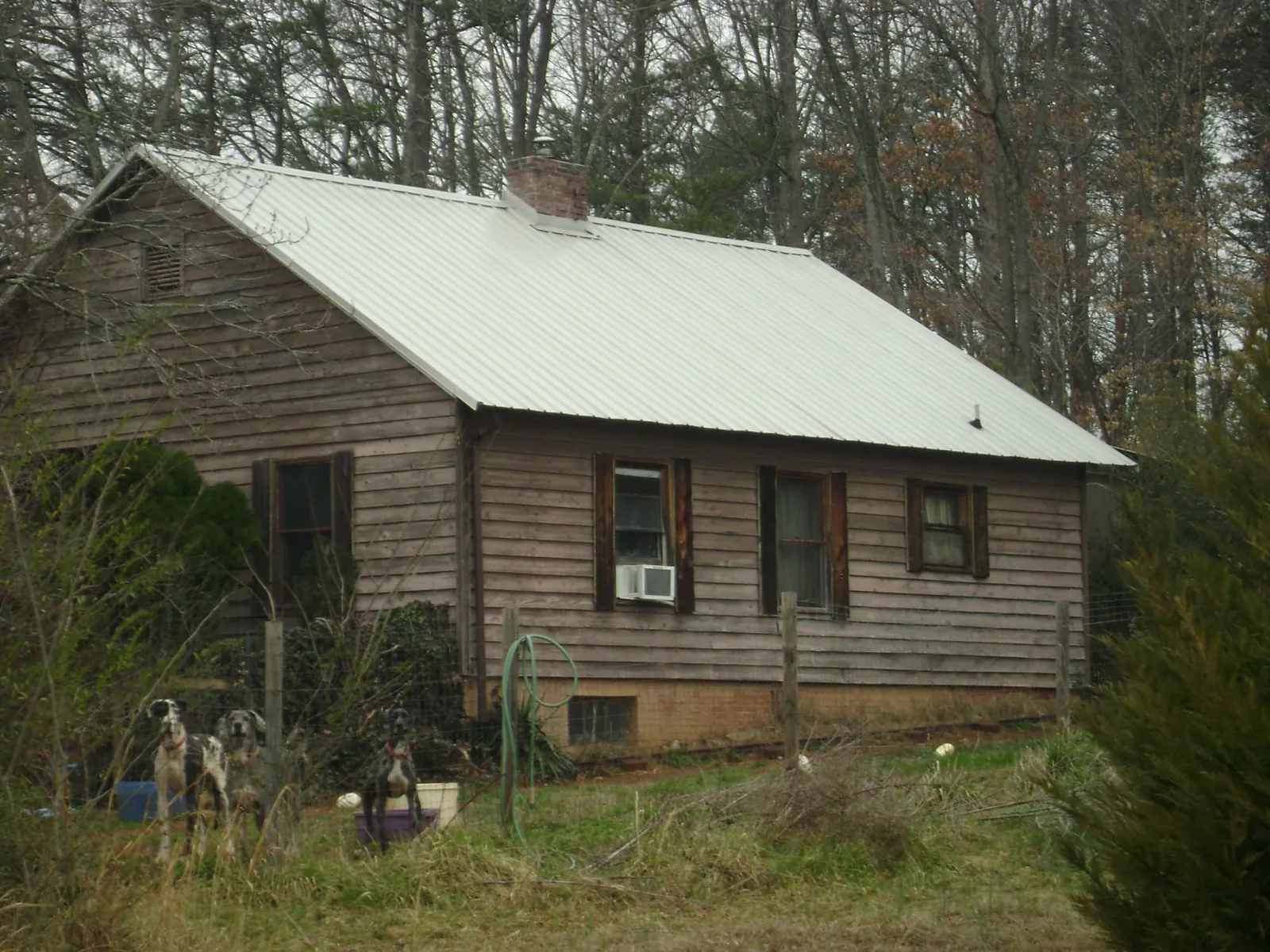 White metal roof on an old wood sided farmhouse, from a Metal Roof Installation job in Johnson Creek